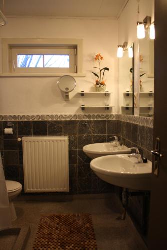 a bathroom with two sinks and a mirror and a toilet at Maison A La Mer in Retranchement
