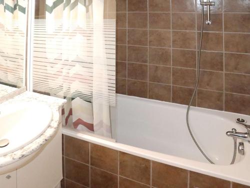 une salle de bain avec une baignoire et un lavabo dans l'établissement Appartement pour 6 pers. avec piscine, jacuzzi et balcon - Les Orres - FR-1-322-510, aux Orres