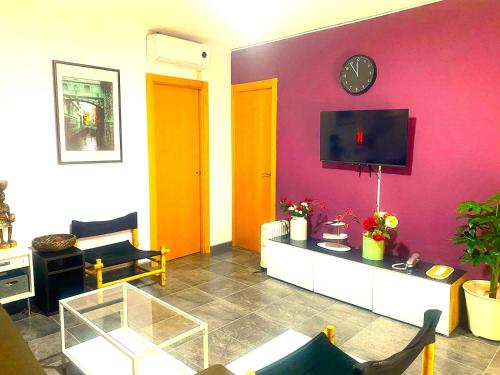 a living room with a red wall with a tv at 3 Bedroom Next to Airport & La Sagrada Familia Metro and FC barcelona Stadium in Hospitalet de Llobregat