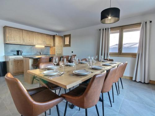 une salle à manger avec une table et des chaises en bois dans l'établissement Spacieux appartement neuf pour 12 avec vues et balcons - FR-1-455-251, à La Plagne Tarentaise