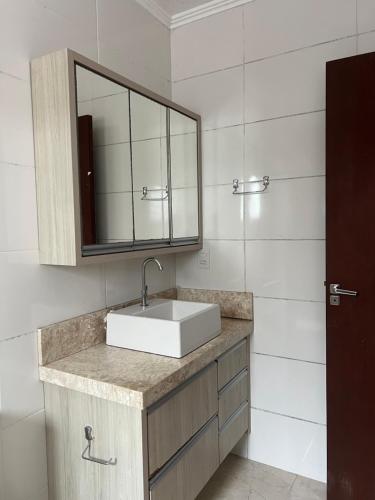 un baño con lavabo y espejo en Casa Maré de Bombas - em Pousada Maré de Bombas, en Bombinhas