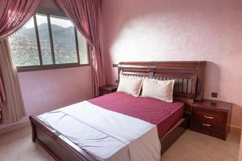 AghbalouにあるBab Atlas appartment N5 in Ourika valleyのベッドルーム1室(赤と白のシーツが敷かれたベッド1台、窓付)