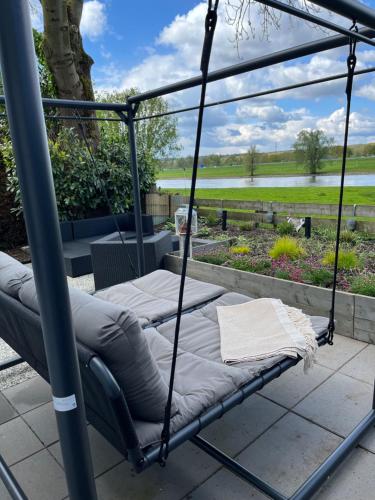 a swing bed on a patio with a view at Chalet-Frank in Lathum
