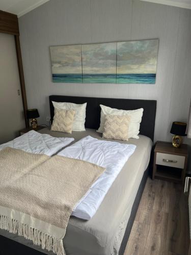 ein Schlafzimmer mit zwei Betten mit weißen Laken und Kissen in der Unterkunft Chalet-Frank in Lathum