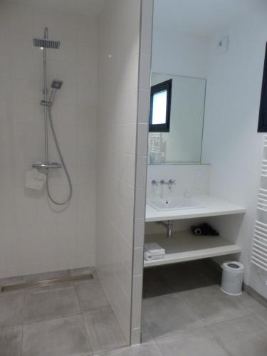 a white bathroom with a shower and a sink at Les Chambres d'hôtes de Kérasquer in Lannilis