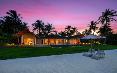 a house on the beach with a sunset at RAAYA By Atmosphere - Premium All Inclusive with Free Transfers in Raa Atoll