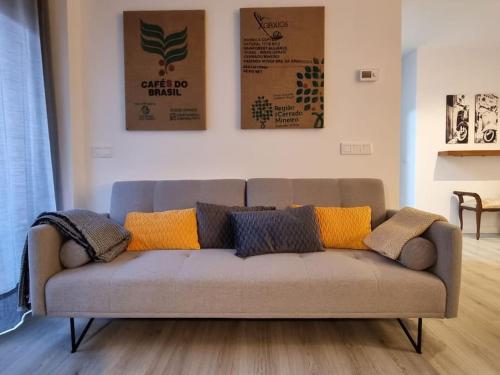 a couch with pillows on it in a living room at QEhome confort y parquing en el centro de Manresa in Manresa