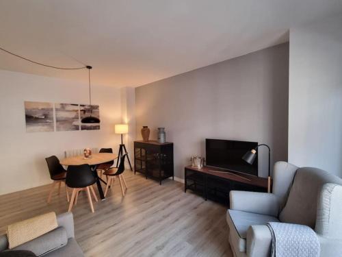 a living room with a couch and a table and a tv at QEhome confort y parquing en el centro de Manresa in Manresa