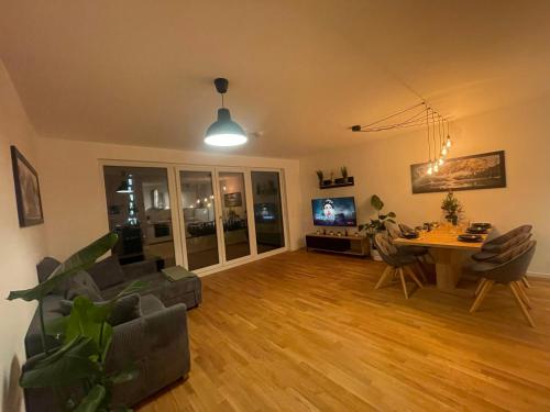 a living room with a couch and a table and a tv at Großzügiges Designer Apartment in Schönefeld