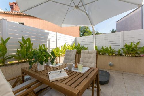 een houten tafel met een parasol op een patio bij Apartments D&D in Dubrovnik