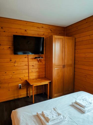 a bedroom with a bed and a flat screen tv at Alpine Escape Studios in Măgura