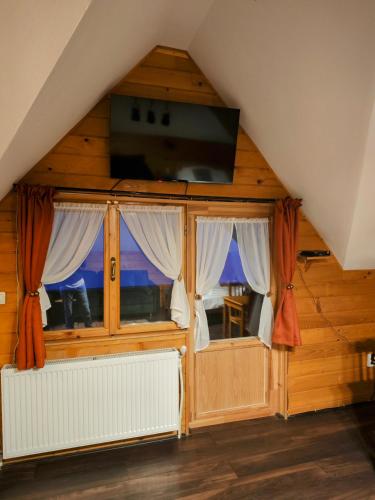 a room with two windows and a flat screen tv at Alpine Escape Studios in Măgura