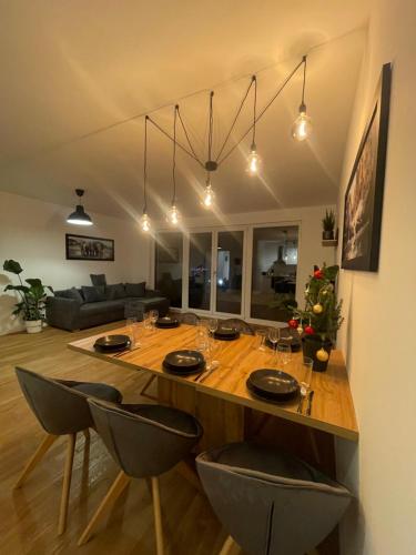 a large wooden table with chairs in a living room at Großzügiges Designer Apartment in Schönefeld