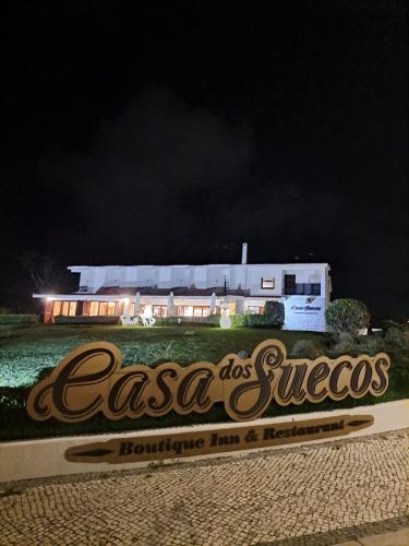 a sign in front of a building at night at Boutique Inn & Restaurant - Casa dos Suécos in Figueira da Foz