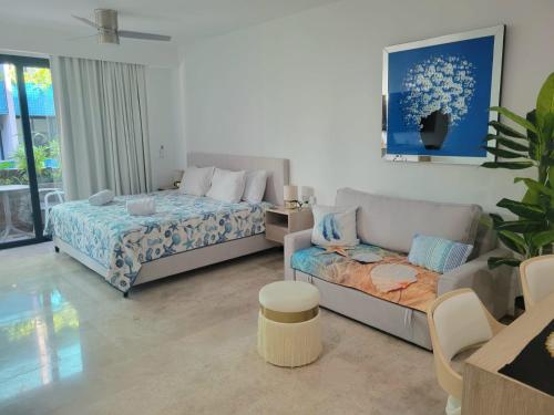 un soggiorno con un letto e un divano di Acogedor Condo a metros de la 5ta Avenida a Playa del Carmen