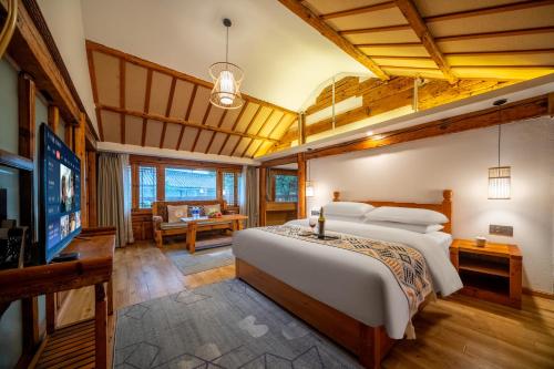 a bedroom with a large bed and a television at Walk Together Hotel in Lijiang