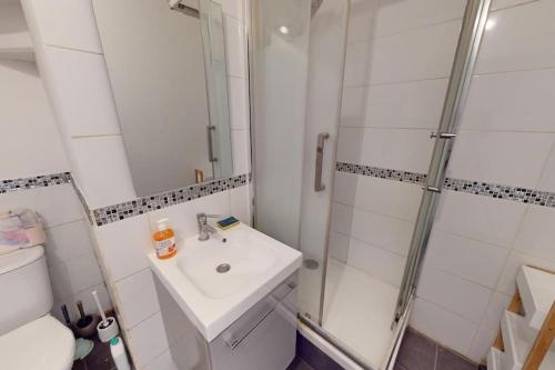 une salle de bain blanche avec une douche et un lavabo dans l'établissement F3 - Rue Casimir Delavigne, au Havre