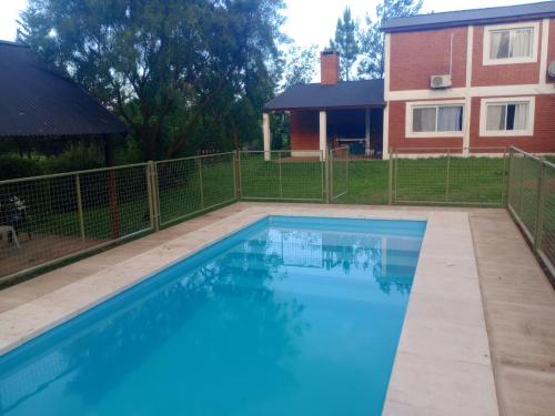 ein großes Schwimmbad vor einem Haus in der Unterkunft Shakty "Apart de Montaña" in Los Reartes