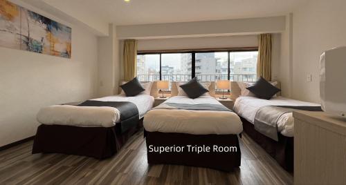 a hotel room with four beds and a window at Le Tour Hotel Akihabara Kanda 楽途ホテル神田秋葉原 in Tokyo