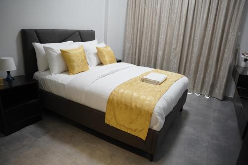 a bedroom with a large bed with yellow pillows at Ista Vacation Homes Rental LLC in Dubai