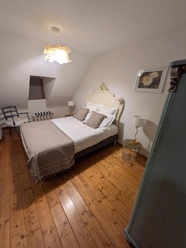 a bedroom with a bed in a room with wooden floors at Les Toits de Turckheim in Turckheim