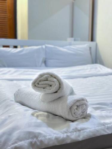 a stack of towels sitting on a bed at Chubbi5 room11 in Bangkok