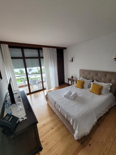 a bedroom with a bed and a desk with a laptop at Boutique Inn & Restaurant - Casa dos Suécos in Figueira da Foz