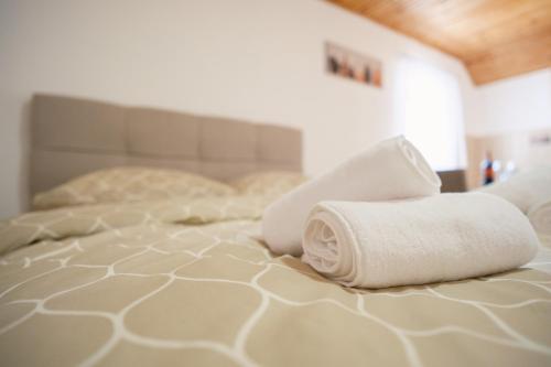 a bed with two rolled towels on top of it at Apartmani Biser Kupresa 4 in Kupres