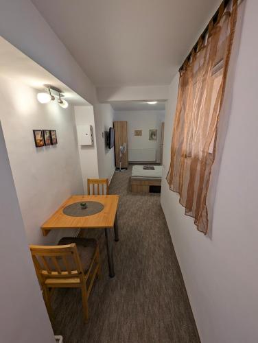 a room with a table and chairs and a bedroom at Sandor Apartment Calarasilor in Târgu-Mureş