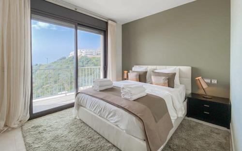 a bedroom with a large bed with a large window at Samara 20 Luxury Apartments Spa Gym Pools Panoramic Views in Marbella