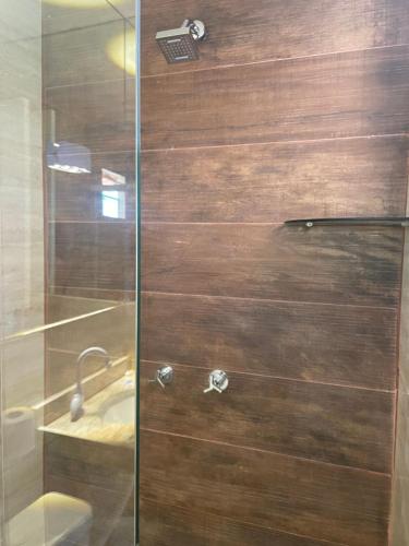 a shower with a glass door next to a sink at Pousada Ceará - Porto das Dunas in Aquiraz