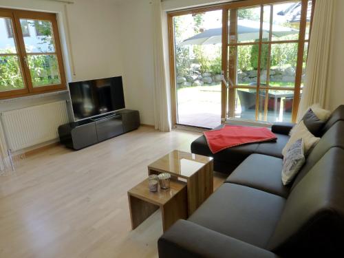 a living room with a couch and a tv at Boutiqueferienwohnung Schnapshäusel in Oberstdorf