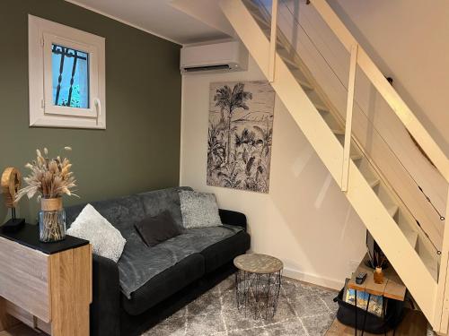 a living room with a couch and a staircase at Porticcio- Duplex dans propriété privée in Cauro