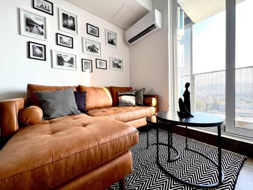 a living room with a couch and a table at Depa con alberca y jardín a 5 min de San Pedro in Monterrey