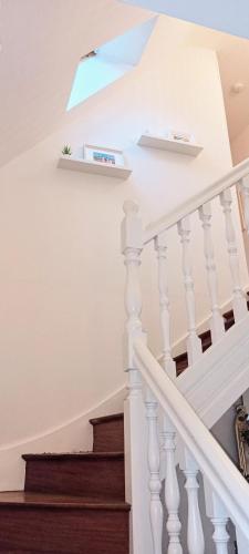 a staircase with white railings and a skylight at Chambre dans maison individuelle in Saint-Renan