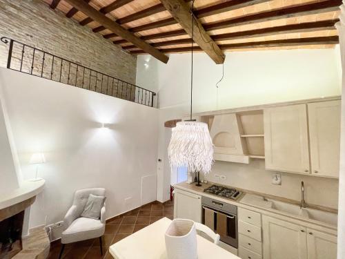 eine Küche mit weißen Schränken und einem Kronleuchter in der Unterkunft Agriturismo Antica Corte in Valiano