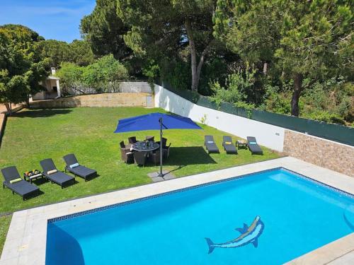 a swimming pool with a table and an umbrella at 4 suites, piscine, Casa Rio-Dora by SesimbraSunSea in Lagoa de Albufeira