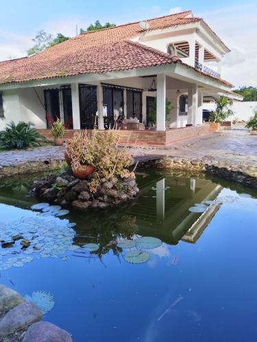 a house with a pond in front of it at Doral House Villavicencio in Villavicencio