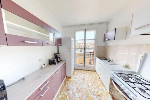 une cuisine avec des armoires roses et blanches et une fenêtre dans l'établissement F3 - Rue Dauphine, au Havre