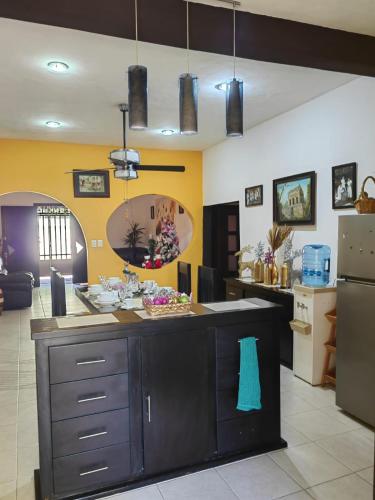 a kitchen with yellow walls and a large island at Casa Fernery in Valladolid