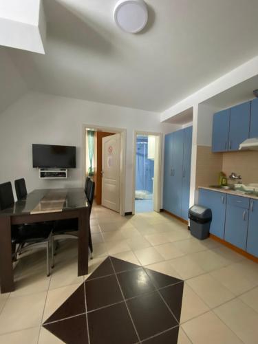 a kitchen and dining room with a table and blue cabinets at Vila Marina Divčibare in Divčibare