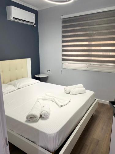 a bedroom with a bed with towels on it at Cambel Luxury Apartment in Sarandë