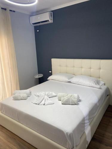 a large white bed with white sheets and pillows at Cambel Luxury Apartment in Sarandë