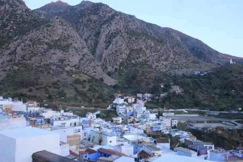 a view of a town with mountains in the background at Riad Zaitouna Chaouen in Chefchaouene