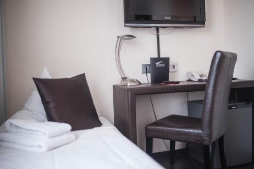 a hotel room with a bed and a desk with a television at Mauritius Komfort Hotel in der Altstadt in Cologne