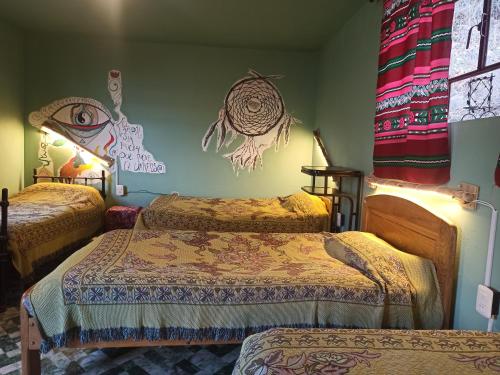 a bedroom with two beds and a mural on the wall at Kasa Kultural Sol y Luna in Copacabana