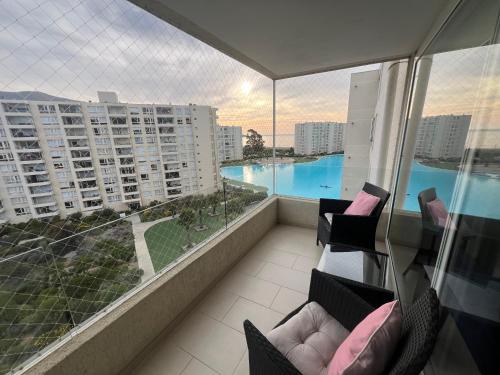 a balcony with chairs and a view of a pool at Papudo Laguna, Depto frente al Mar in Papudo