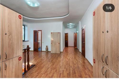 an empty room with wooden doors and a hard wood floor at Достык Хостел in Almaty