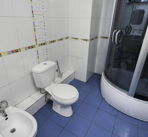 a bathroom with a white toilet and a sink at Достык Хостел in Almaty