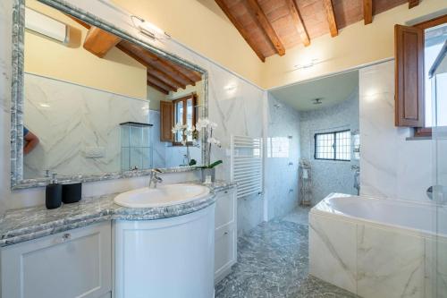 a bathroom with a sink and a tub and a mirror at Lussuoso appartamento vista Duomo in Florence